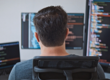 man writing code on a computer