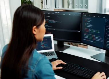 woman writing code on a computer