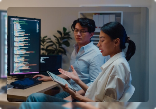 two people working together on a computer and tablet